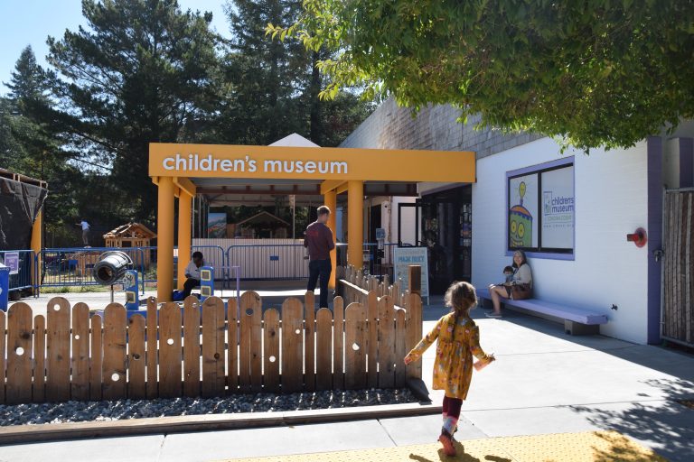 child running towards a sign that says "Children's Museum"
