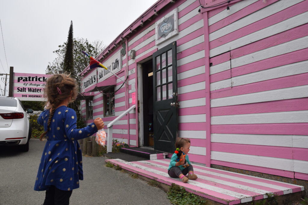 Two children outside of Bodega Bay's pink striped taffy shop Patrick's