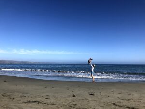Adult throwing a baby in the air at Doran Beach in Bodega Bay