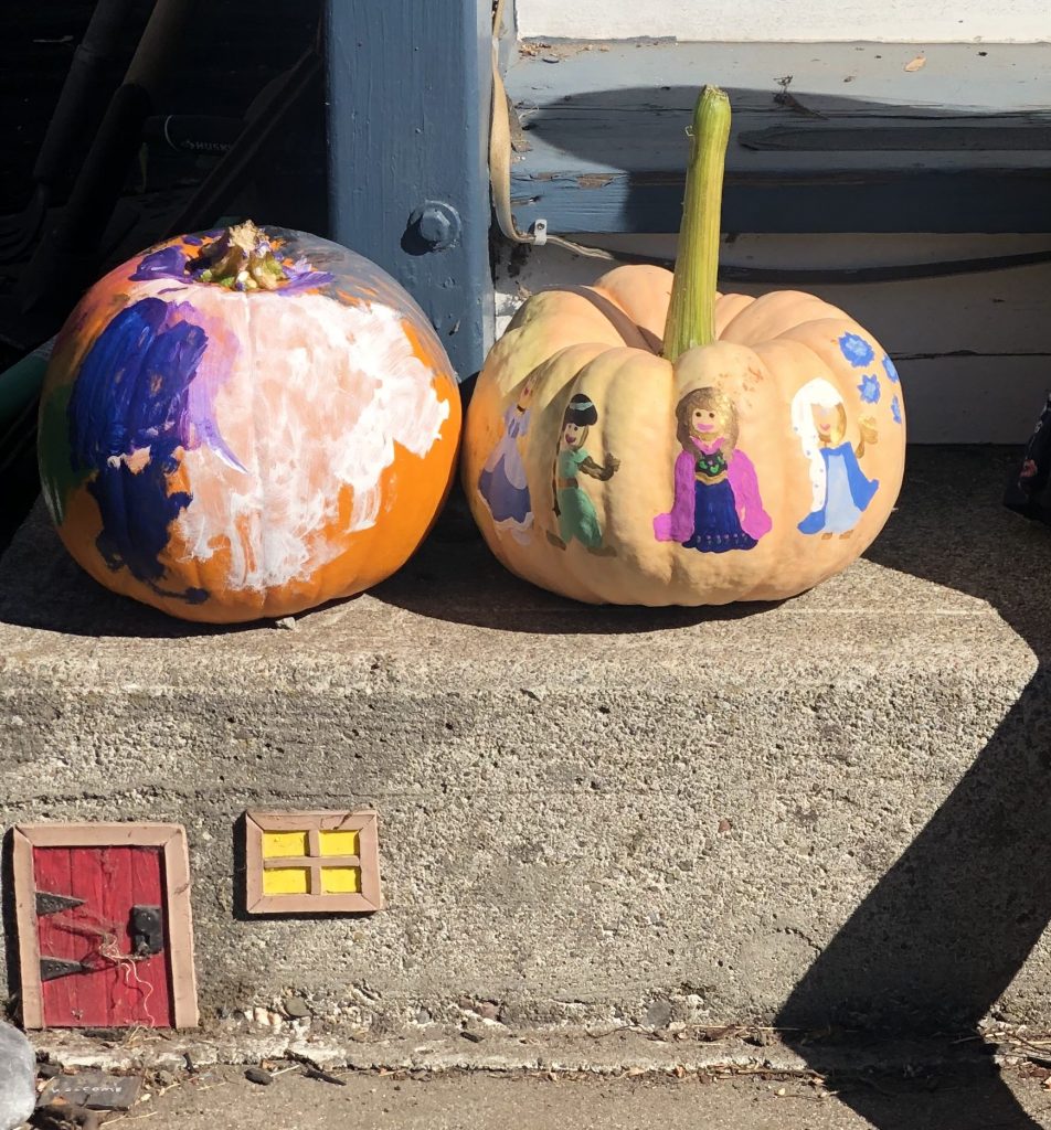 two painted pumpkins on a stoop