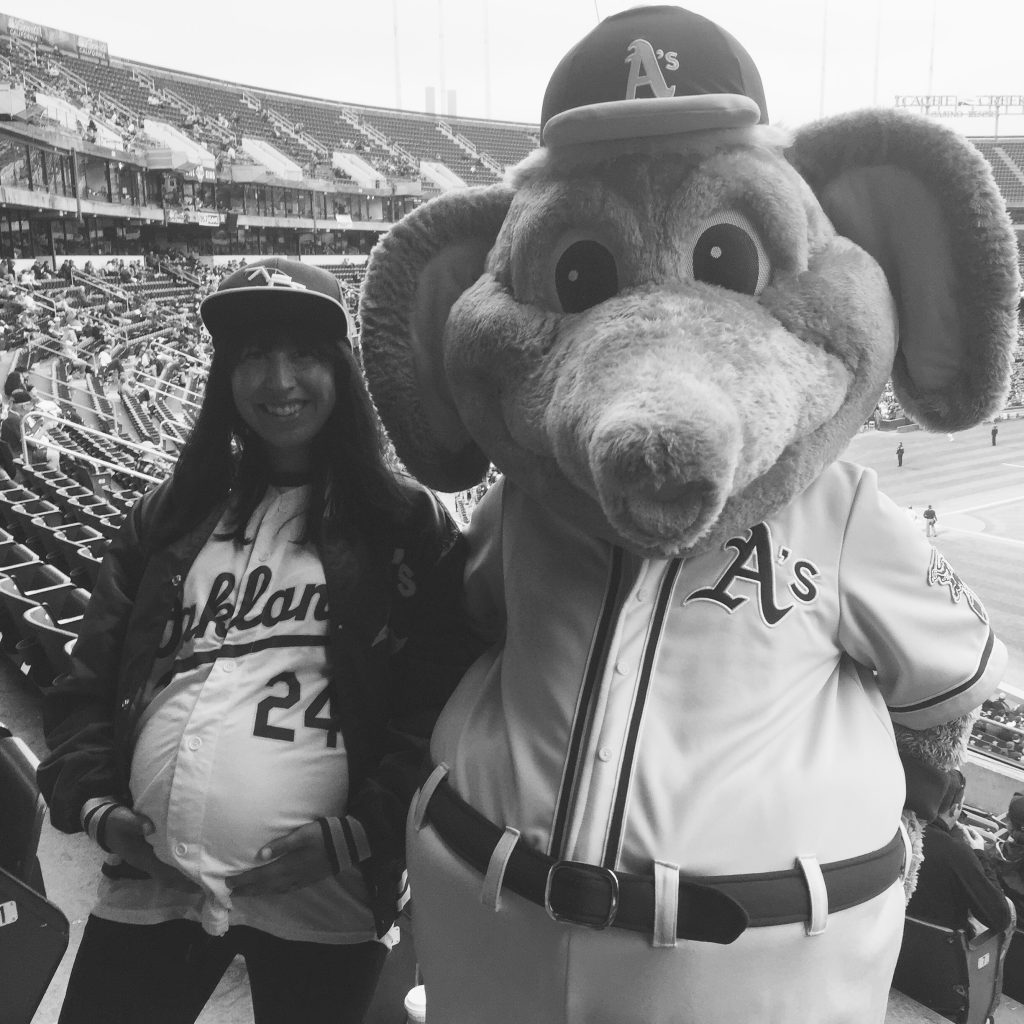 pregnant person standing next to Stomper - the oakland athletics elephant mascot