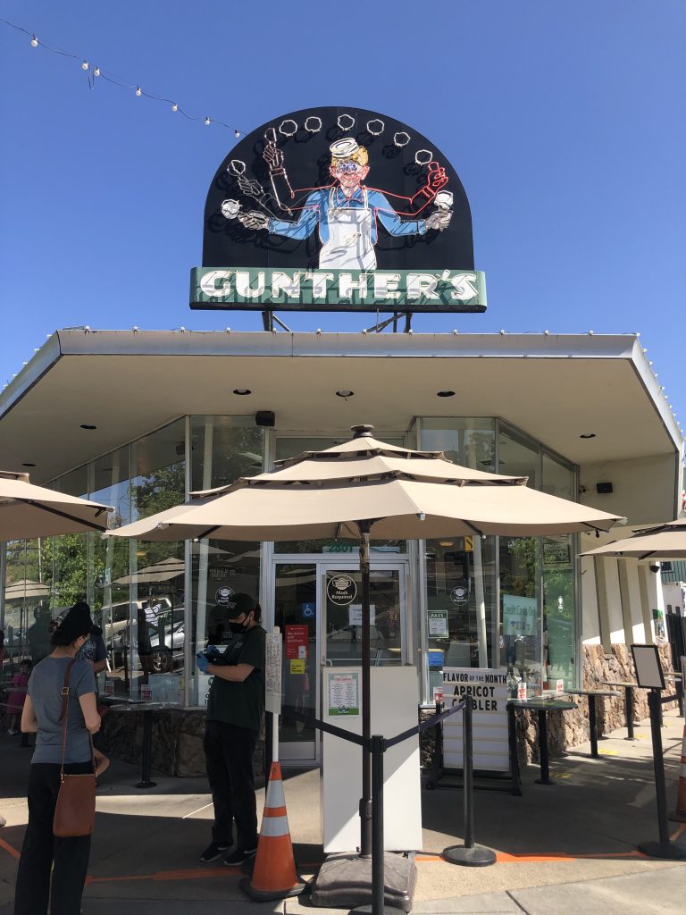 An image of the storefront of Gunther's Ice Cream, with a sign atop showing a vintage image of a server holding ice cream above the Gunther's sign.