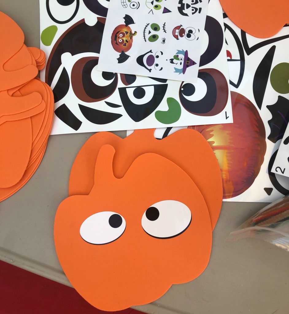 pumpkin cut outs with eye stickers on a table