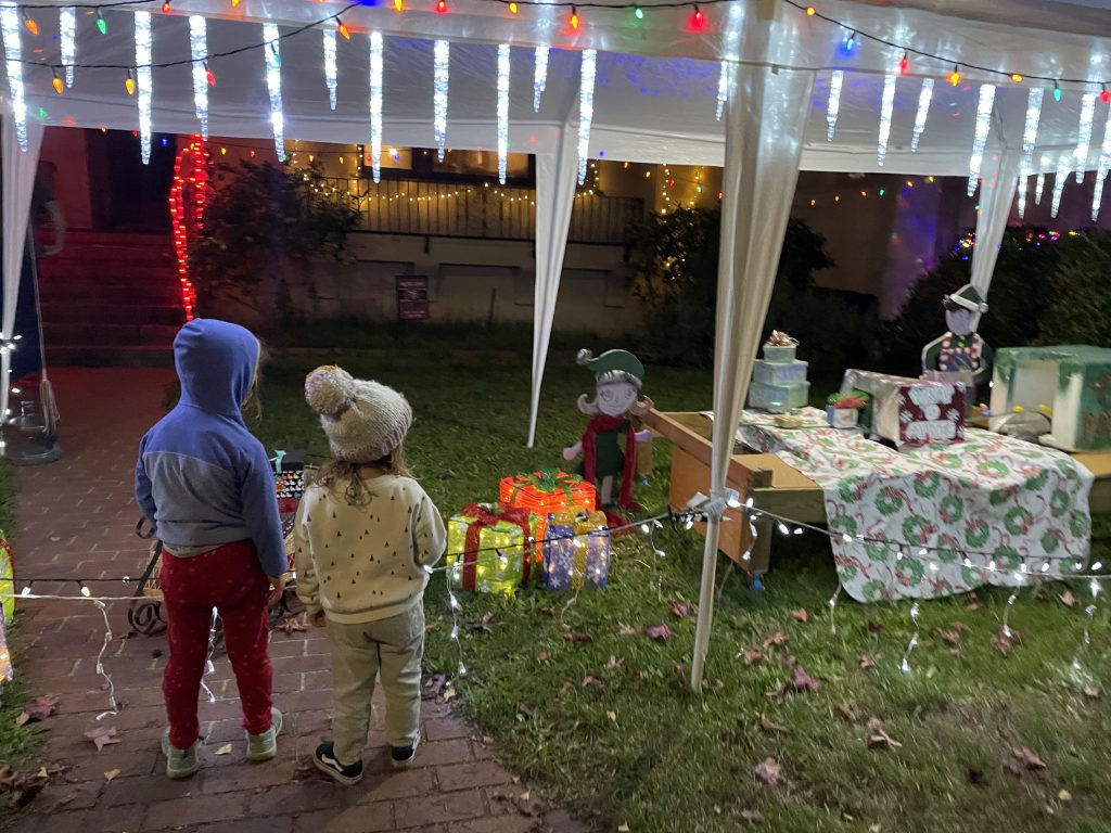 Two children looking at a toy machine on Christmas Tree Lane in Alameda California