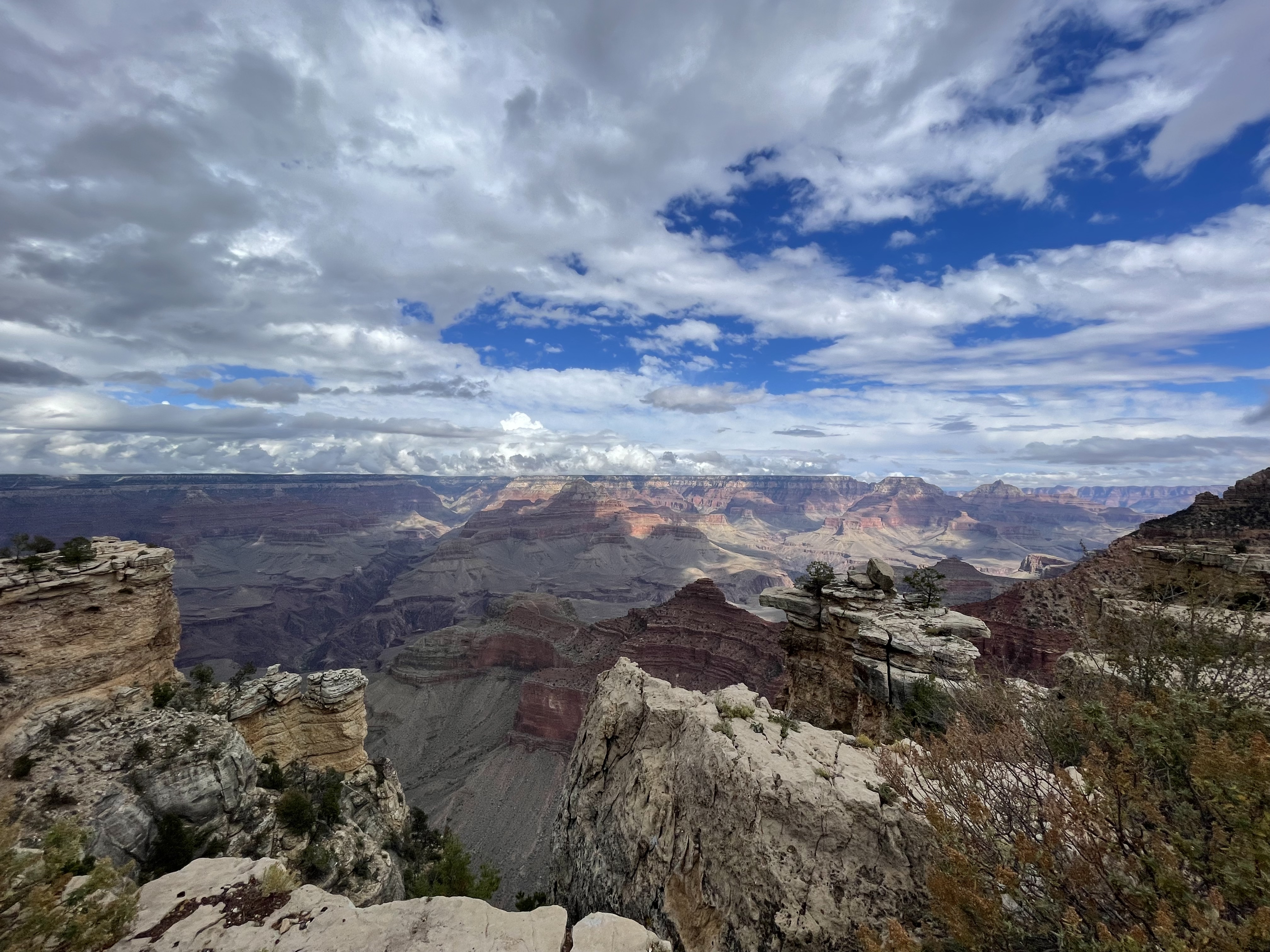 Clouds gather against a blue sky over a sweeping view of the Grand Canyon from Mather Point.