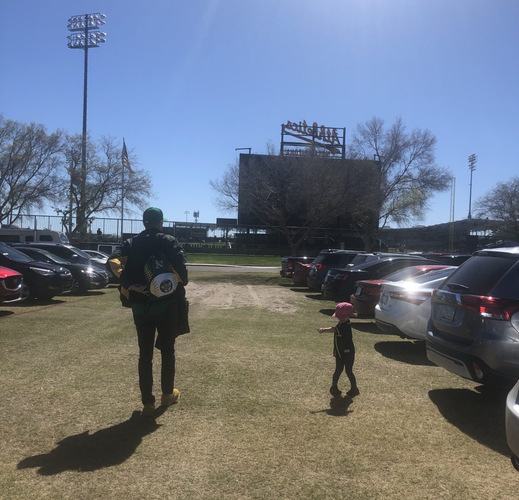 An adult and child walking to Hohokam Stadium for Spring Training