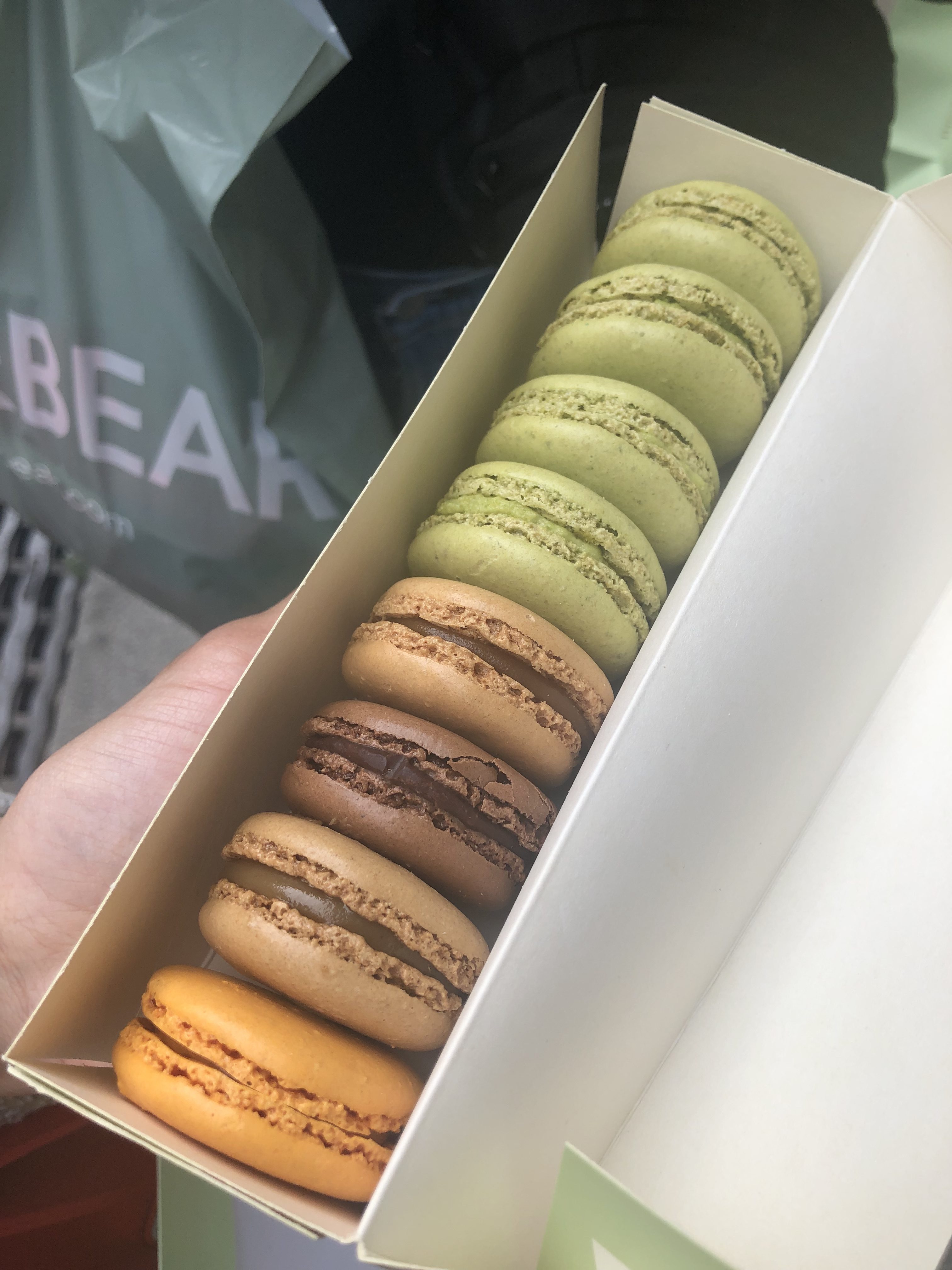 A set of eight colorful macarons from Laduree sits neatly in a box.