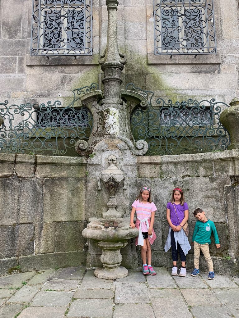 Three kids in front of a fountain in Porto, Portugal