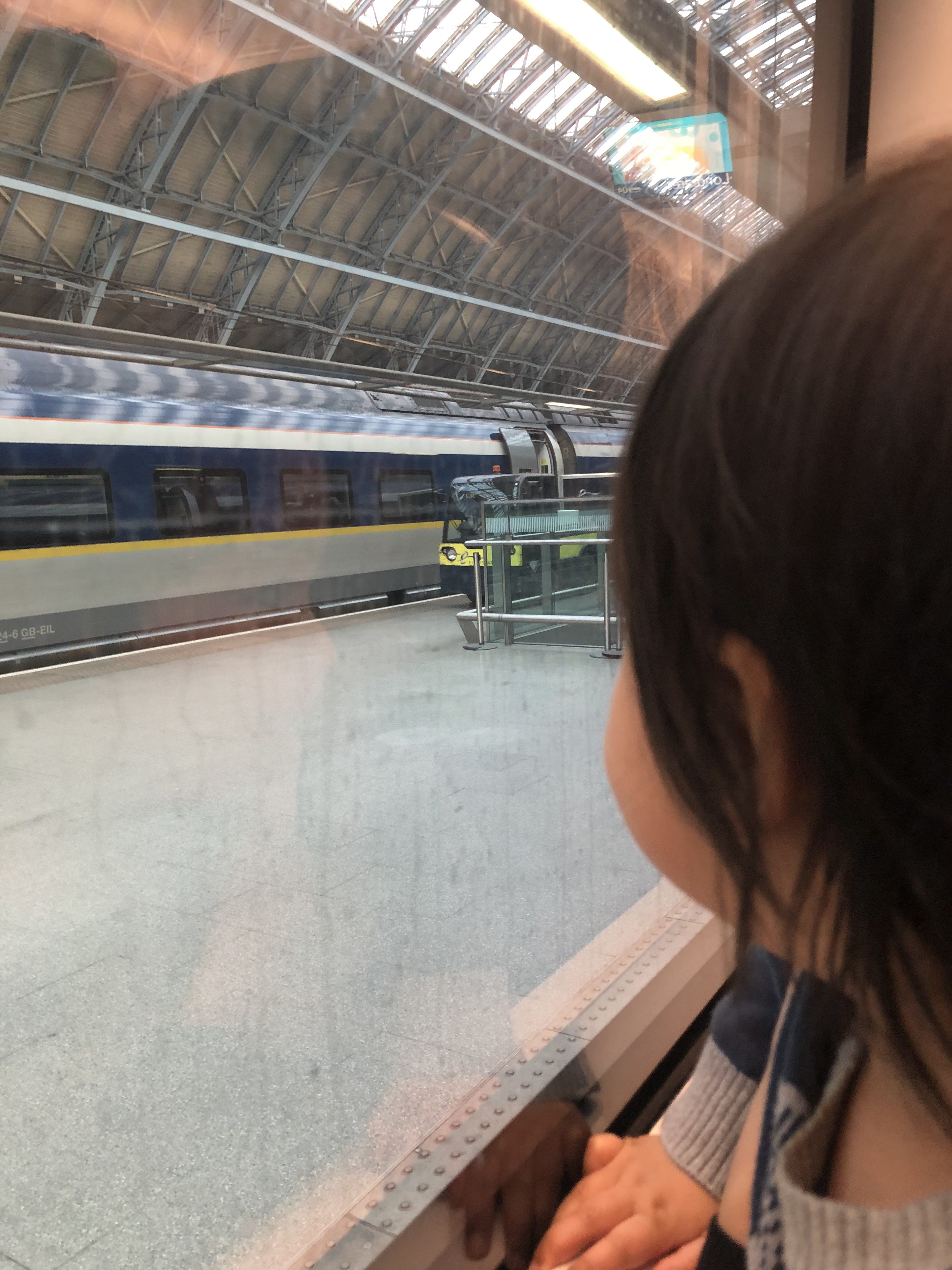 A child looks out the window of a train.