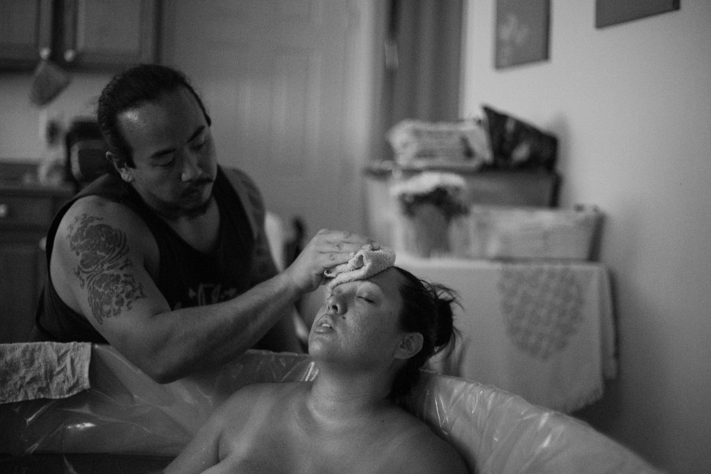 pregnant person laboring in a birthing tub in Hawaii during a home birth