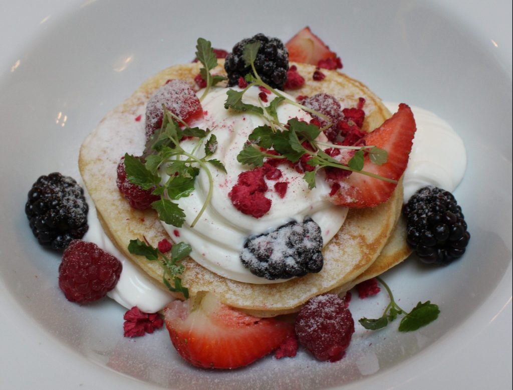 Pancakes topped with fresh strawberries, blackberries, and raspberries