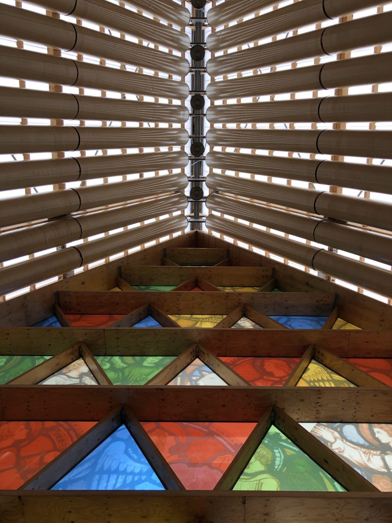 Rows of cardboard columns on top of stained glass triangles at the Cardboard Cathedral in Christchurch, NZ