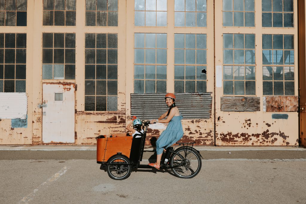 woman riding a Ferla Family cargo bike at Alameda Point