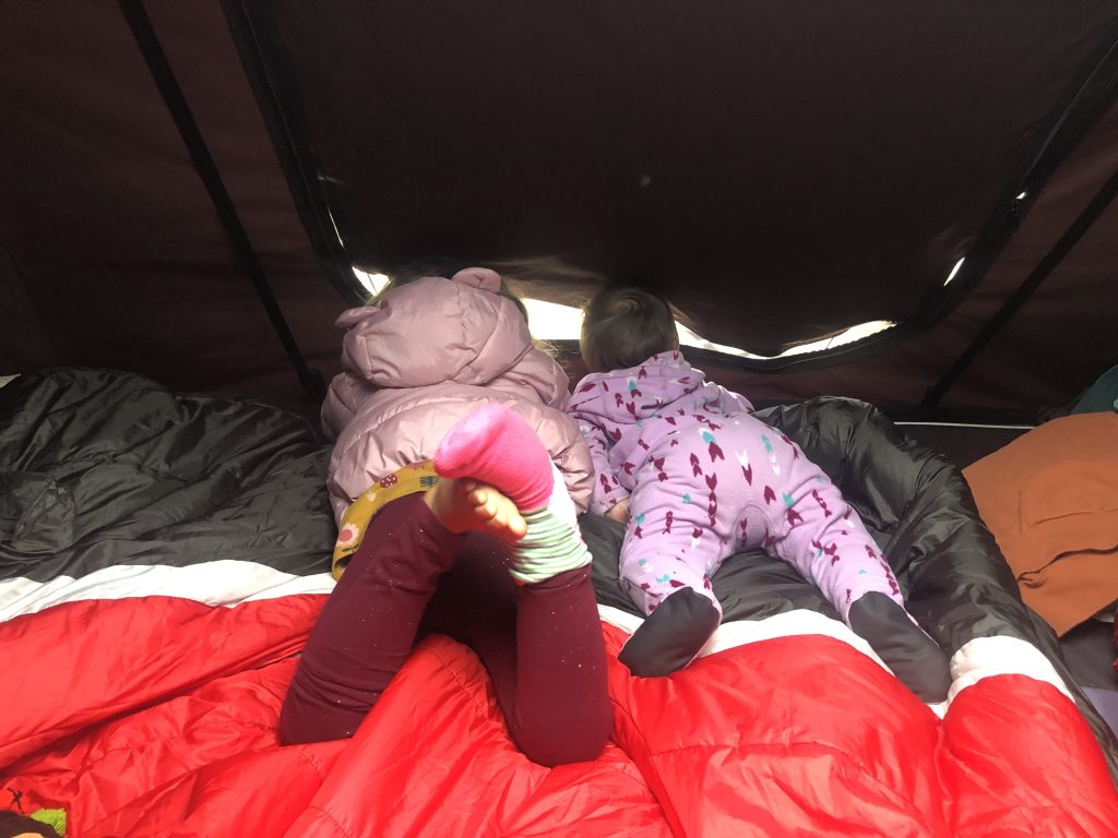 Two children looking out of the top of an iKamper roof top tent RTT