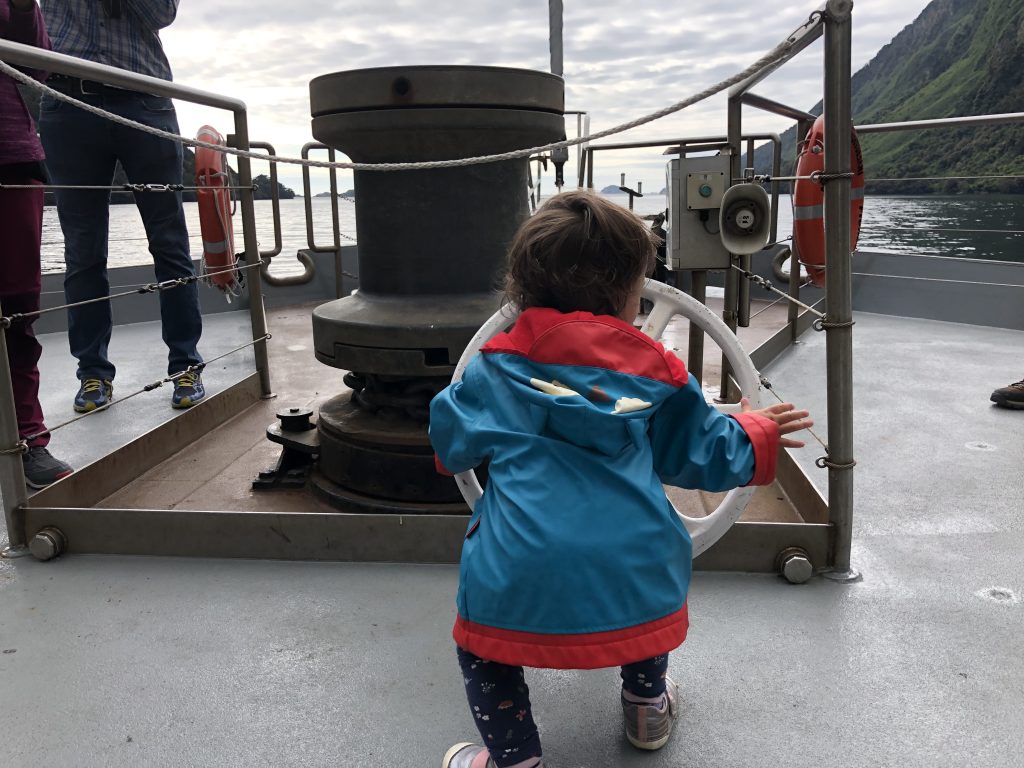 Child in a blue and red rain coat on the Doubtful Sound cruise ship in New Zealand