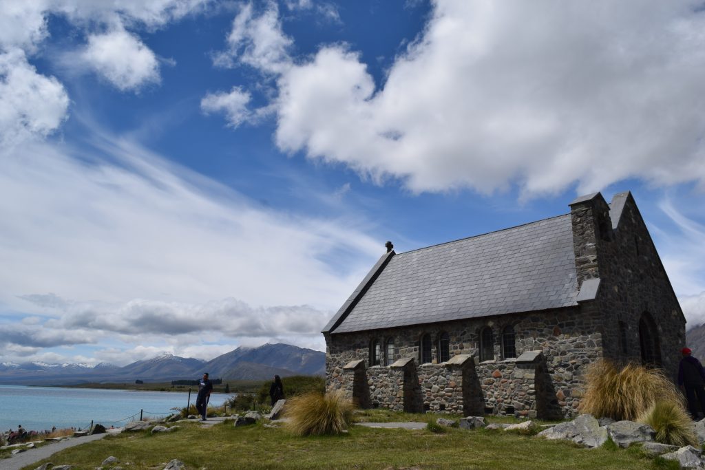 The Church of the Good Shepard on the bank of Lake Tekapo surrounded by mountains and blue skies with clouds