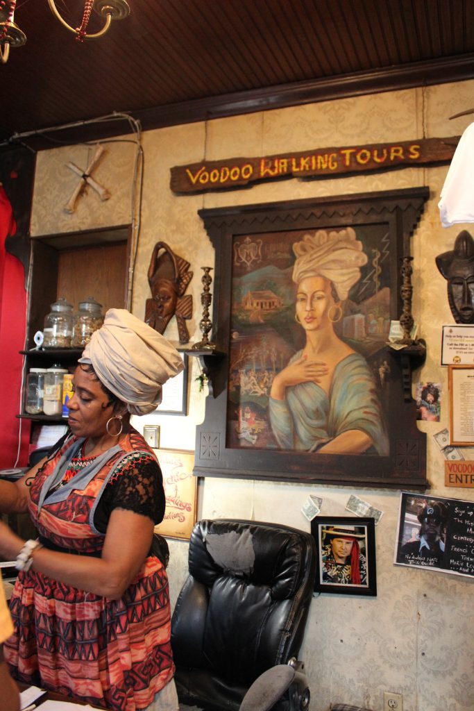 A portrait of Marie Laveau hangs under a sign that says "voodoo walking tour"