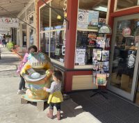 Two children hugging a frog statue in Murphys California for the Frog Jumping Competition
