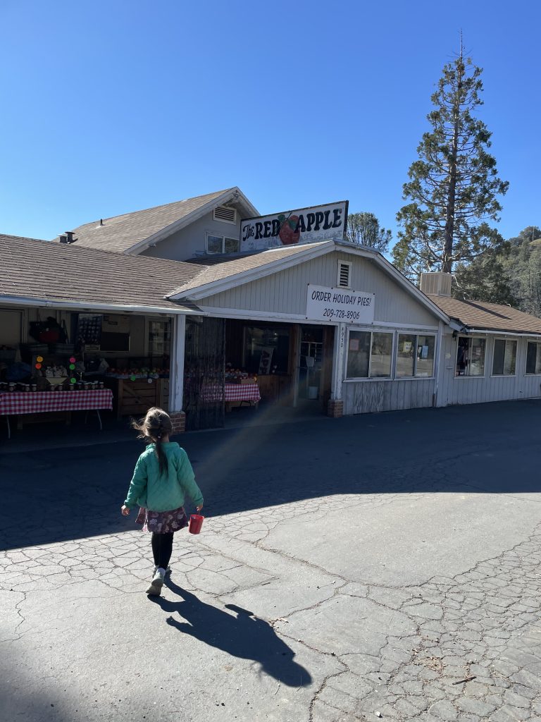 Child walking towards the Red Apple pie shop in Murphys California