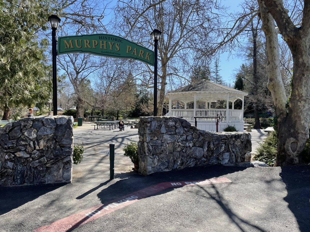 Sign welcoming you to Murphys Community Park with a gazebo off Main Street