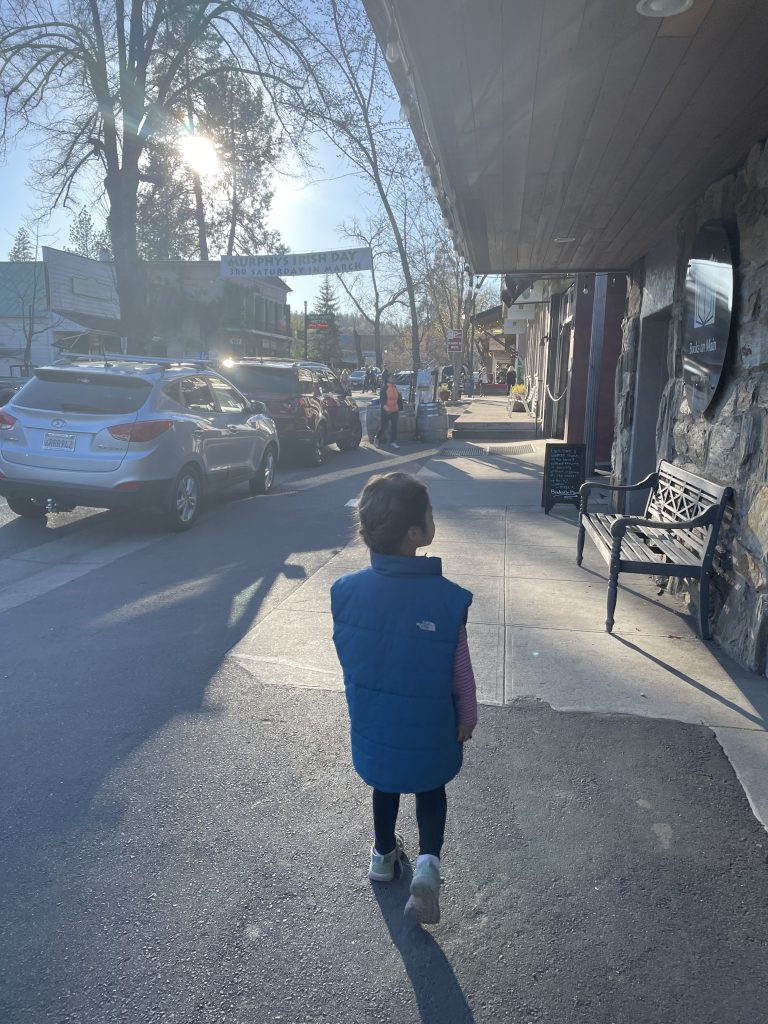 child in a vest walking down Murphys Main Street