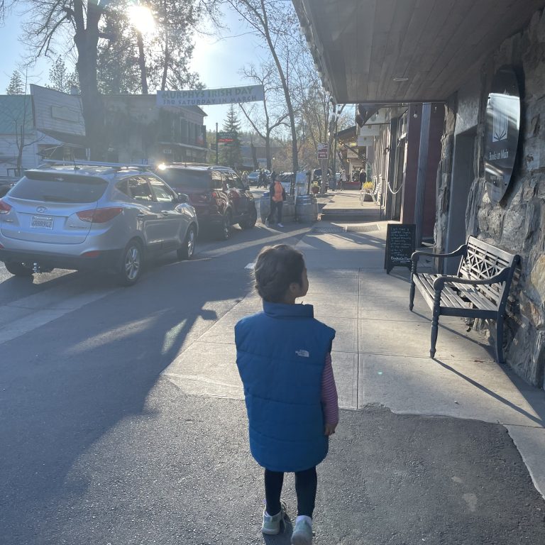 child in a vest walking down Murphys Main Street