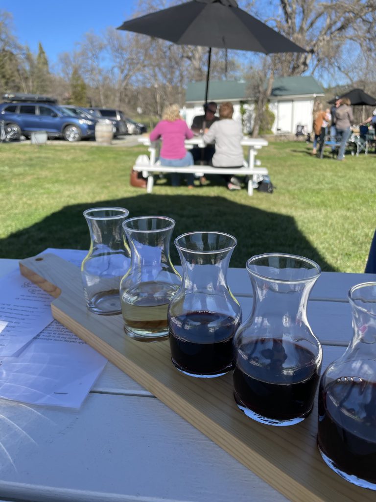 A wine flight on a picnic table at Indian Rock Vineyards in Murphys California