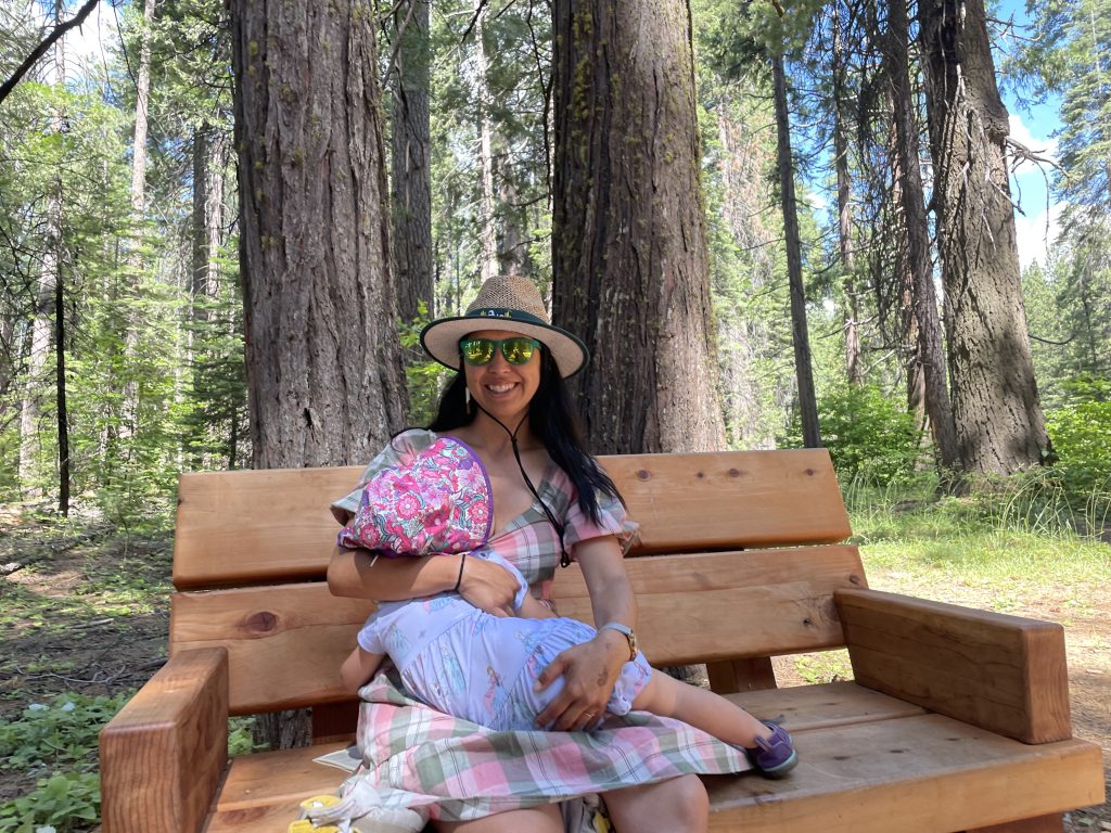 A nursing parent on a picnic bench at Calaveras Big Trees State Park in Arnold