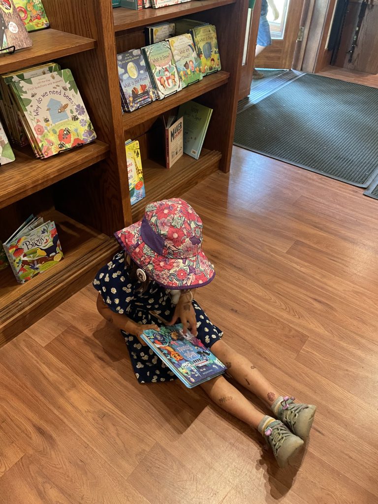 A child reading a book at the Calaveras Big Trees State Park Visitor's Center in Arnold