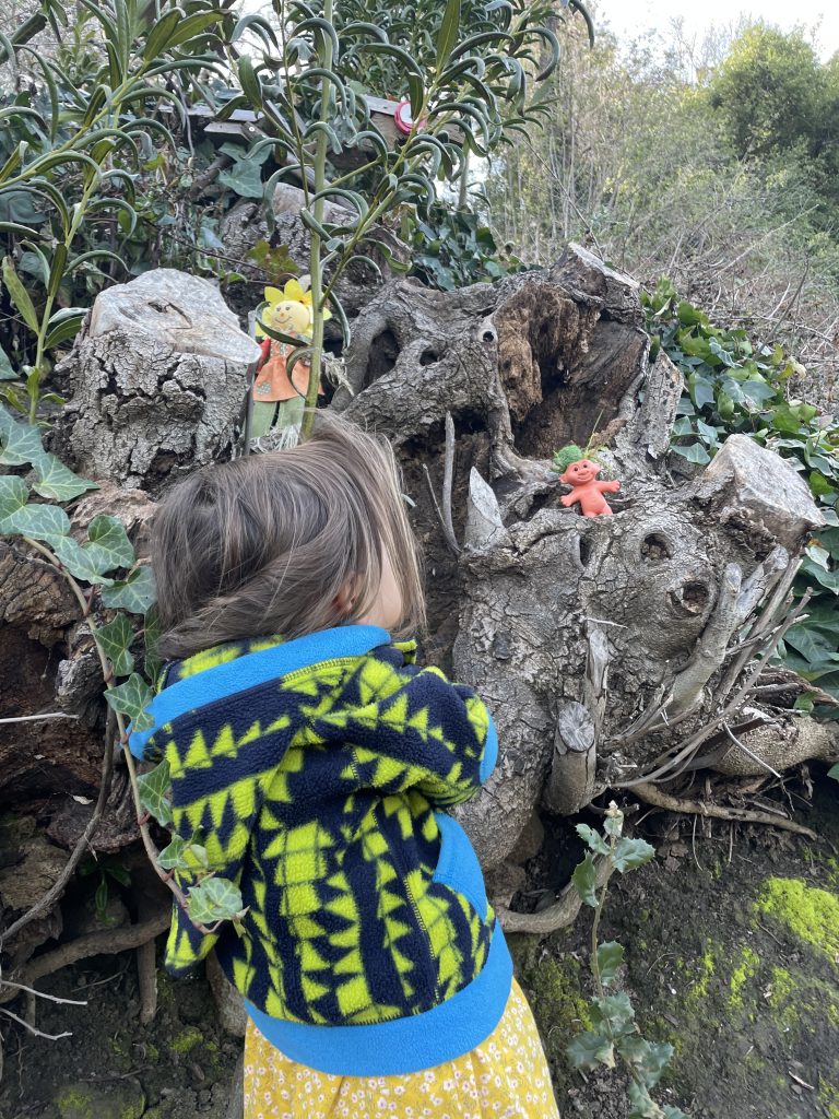 Child wearing a patagonia fleece observing a troll along the bridgeview troll trail in oakland california