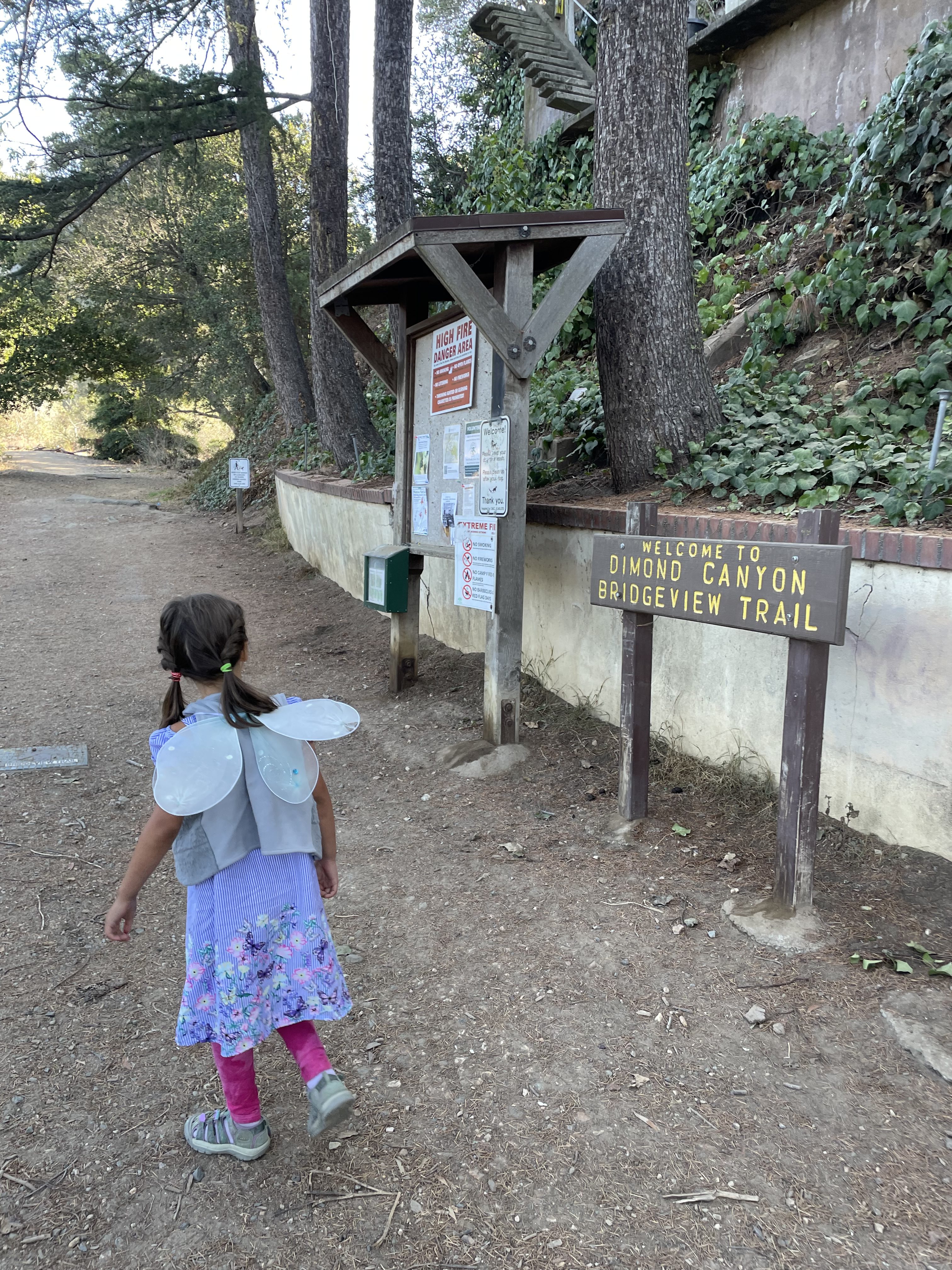 Child in fairy wings at the Bridgeview Troll Trailhead in Oakland