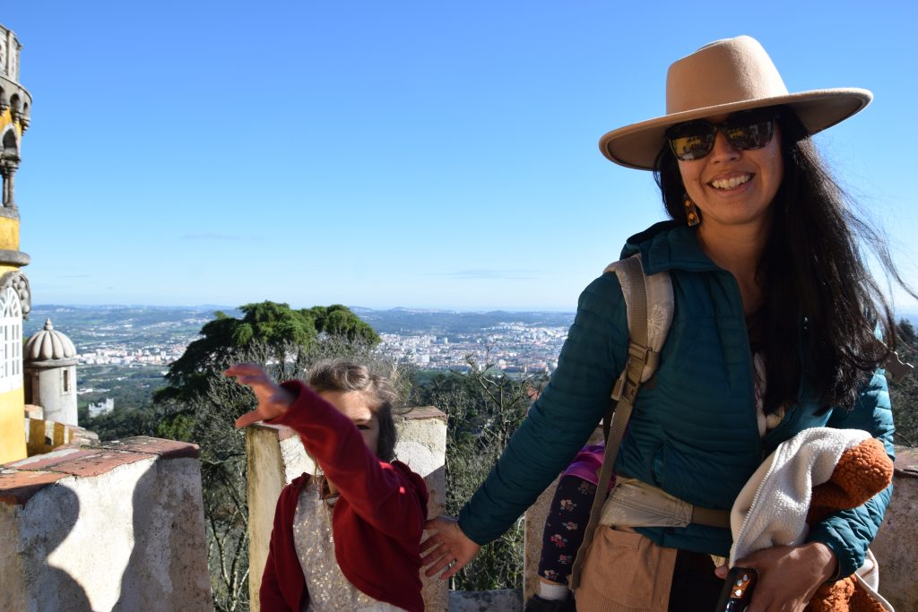 An adult with a hat and a child on top of Pena Palace in Sintra
