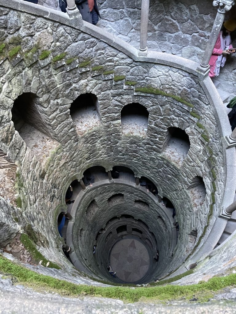 A stone spiral staircase into the Initiation Well of Quinta da Regaleira in Sintra, Portugal