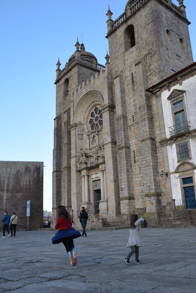 Child running towards the Se Cathedral in Porto, Portugal
