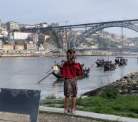 A child staring at the Dom Luis I Bridge in Porto, Portugal