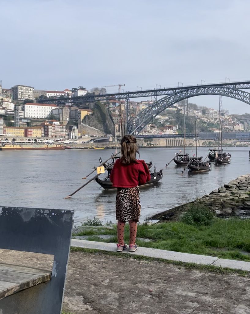 A child staring at the Dom Luis I Bridge in Porto, Portugal