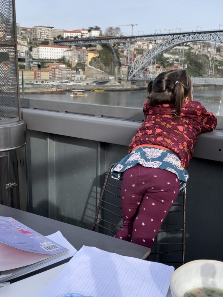 Child enjoying the view from the 360 Terrace Restaurant at Porto Cruz in Portugal of the Douro River and Dom Luis I Bridge