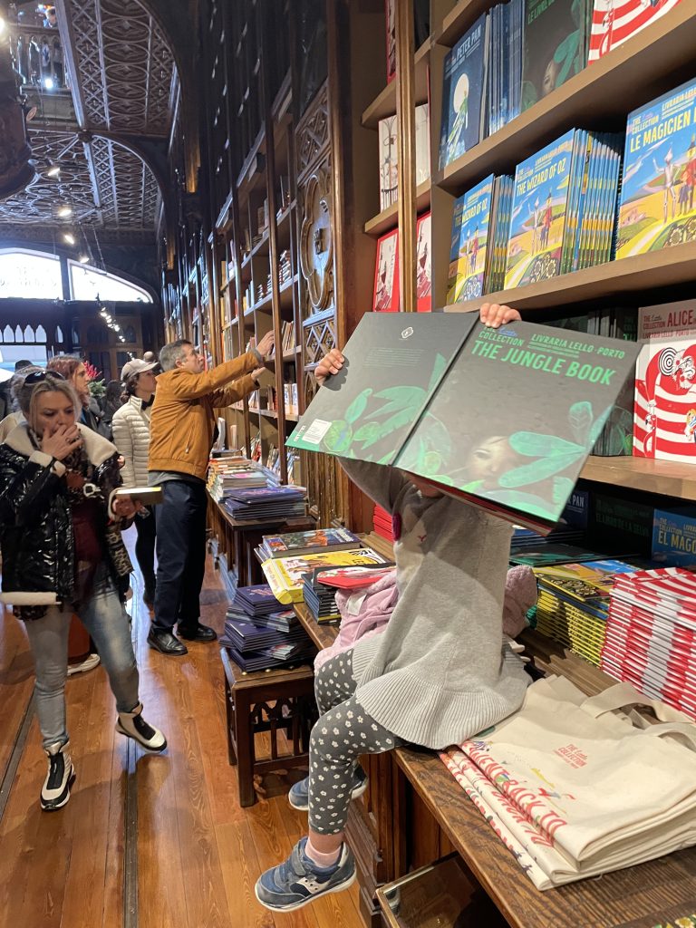 Child reading a book in the Livraria Lello bookstore in Porto Portugal