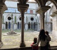 Adult and children looking into a courtyard of Se Cathedral in Portugal