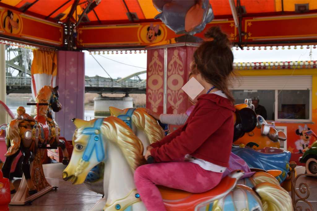 two children riding the merry-go-round in Alcacer do Sal Portugal