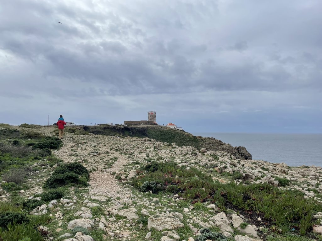 Adult and child walking to the Faro do Sao Vicente in Sagres, Portugal
