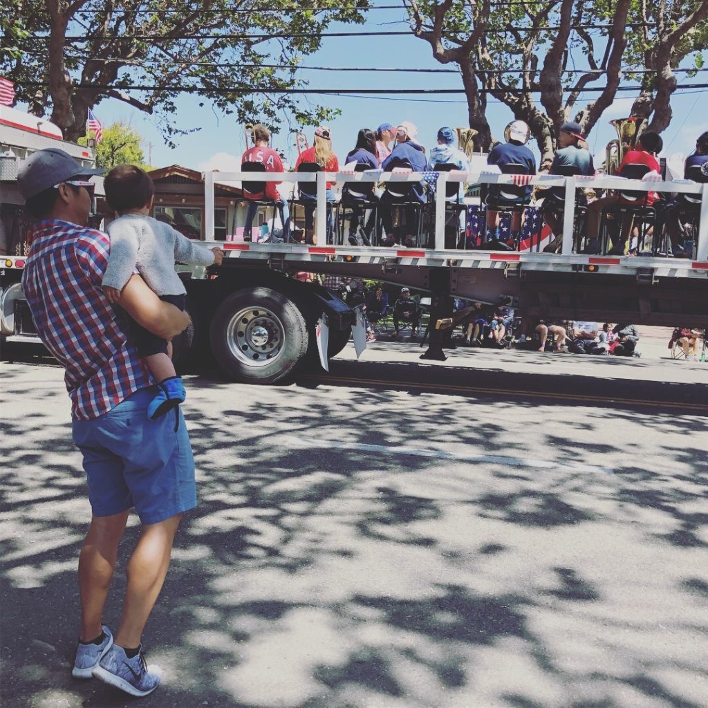 An adult holding a child looking at a fire truck in the 4th of July Parade in Alameda California