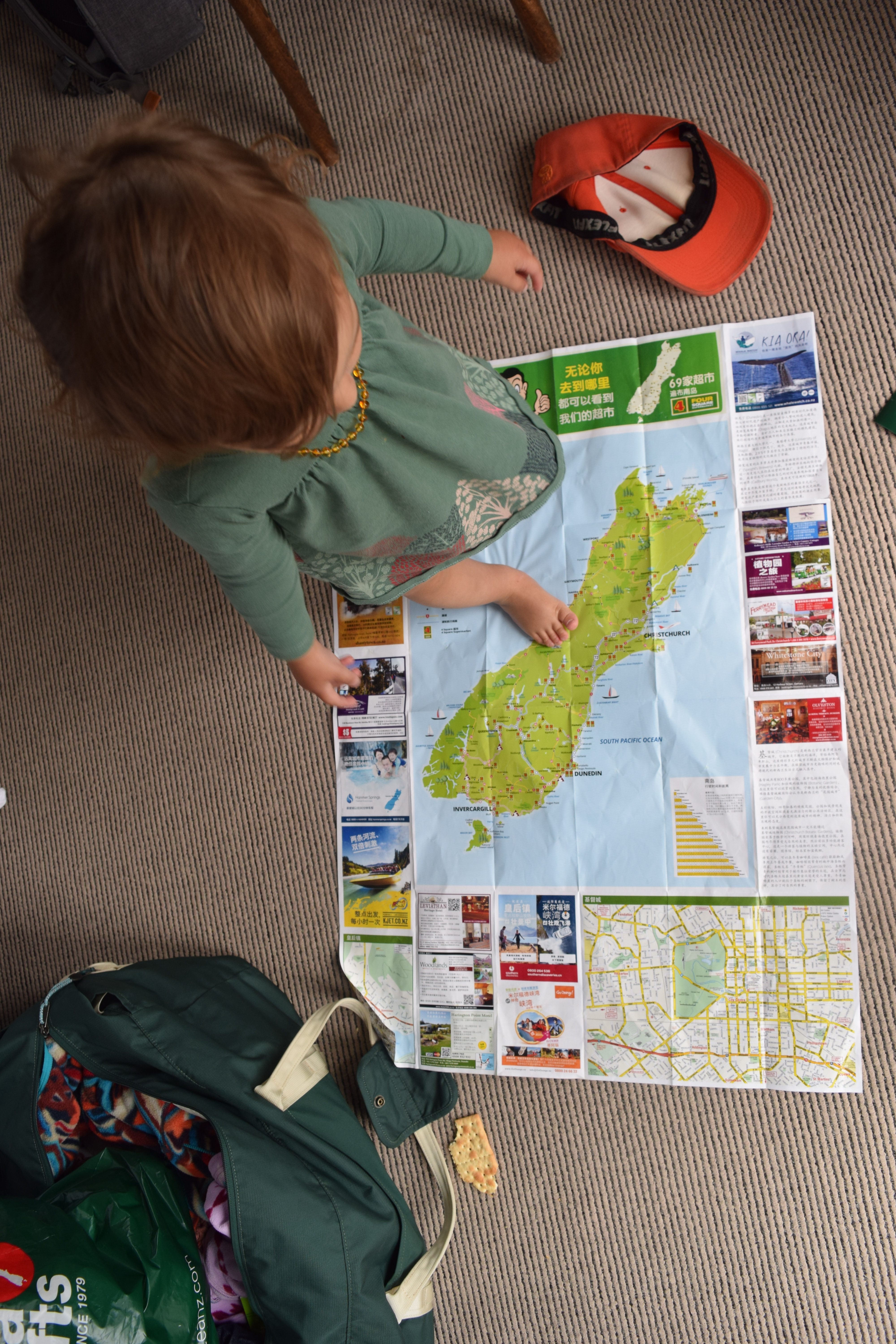 A child standing on top of a map of the South Island of New Zealand