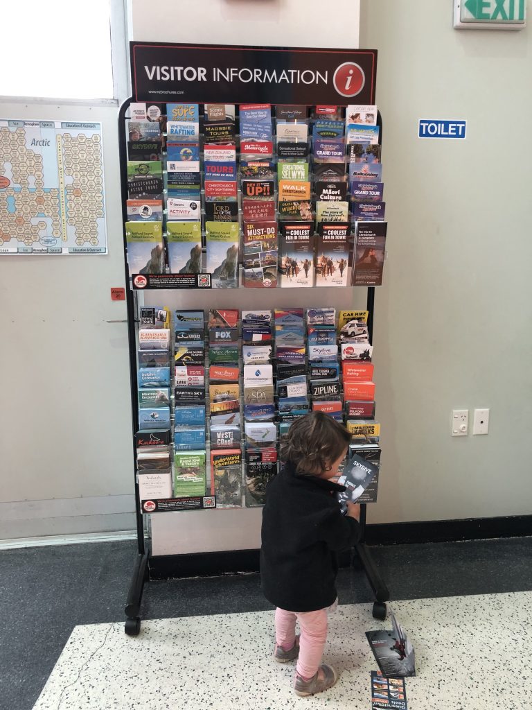 child looking at travel brochures in New Zealand