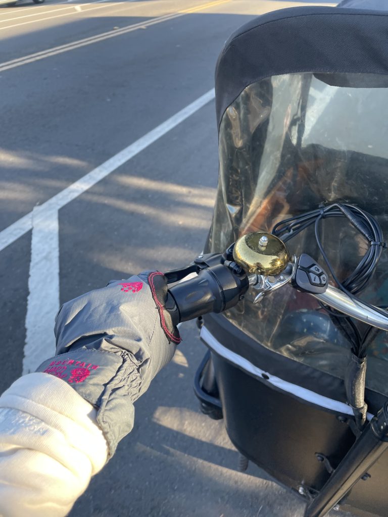 Mountain Hardwear gloves on a hand riding a cargo bike