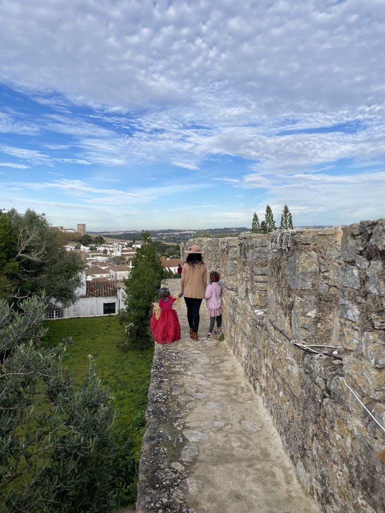 Family walking along the castle walls of Obidos, Portugal