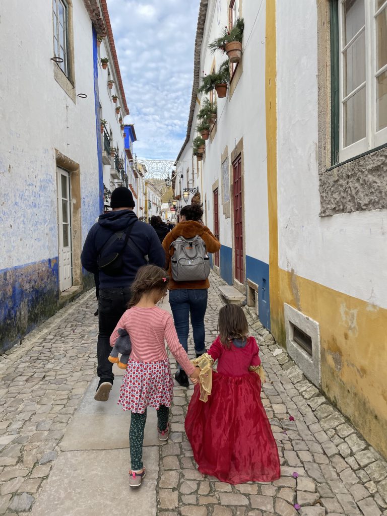 Children in princess dresses walking down Rua Direta in Obidos Portugal