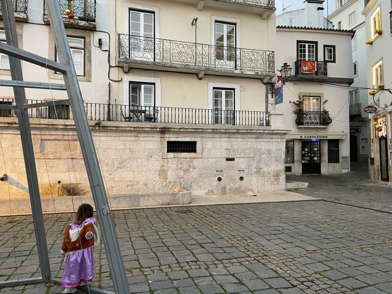 A child wandering Lisbon's cobblestone streets.