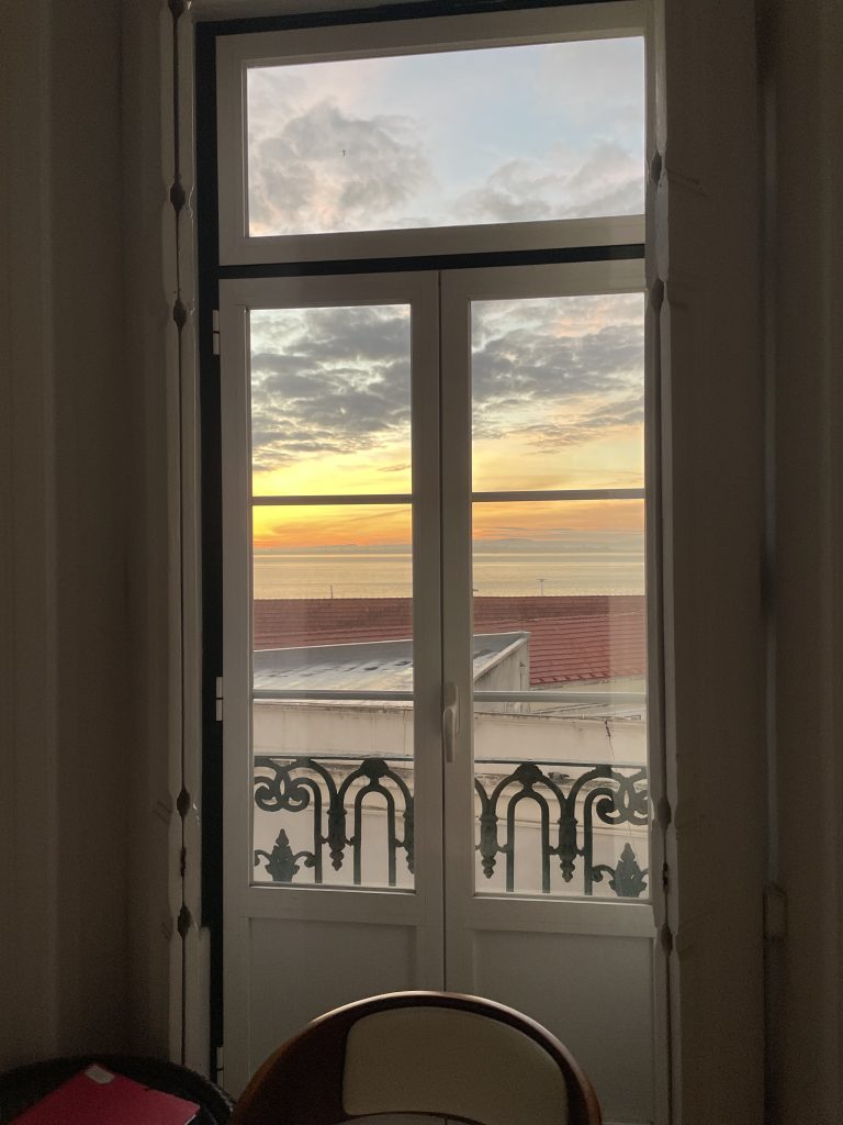 A view out a window of sunrise in Lisbon Portugal from the Alfama