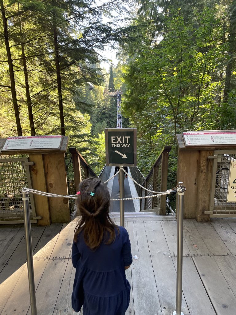 A child standing in front of the exit sign for the Capilano Suspension Bridge